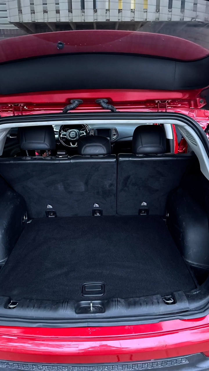 Clean black cargo area inside a red vehicle during the ShineTime detailing process
